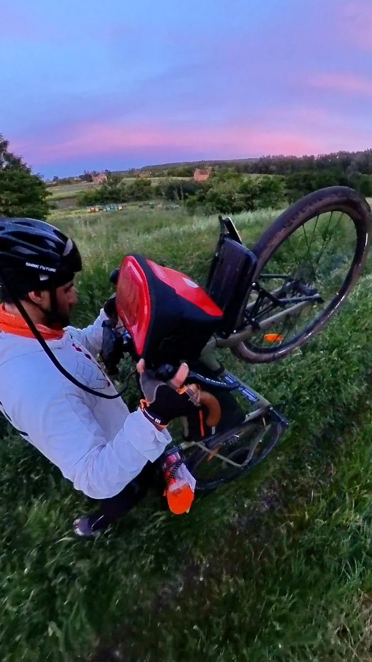 Repairing a touring bicycle beside a field